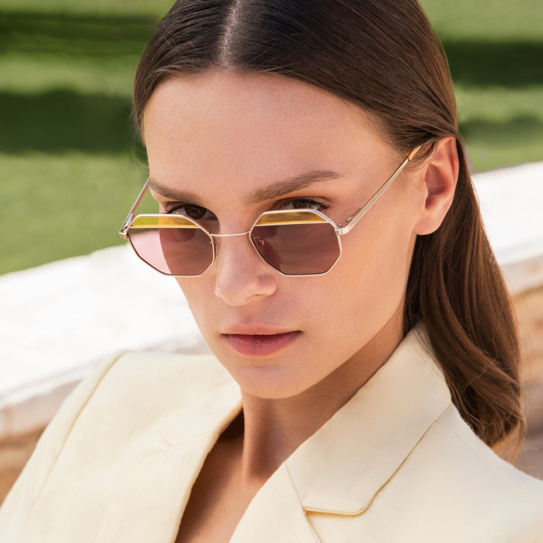 a woman wearing sunglasses and a white shirt 