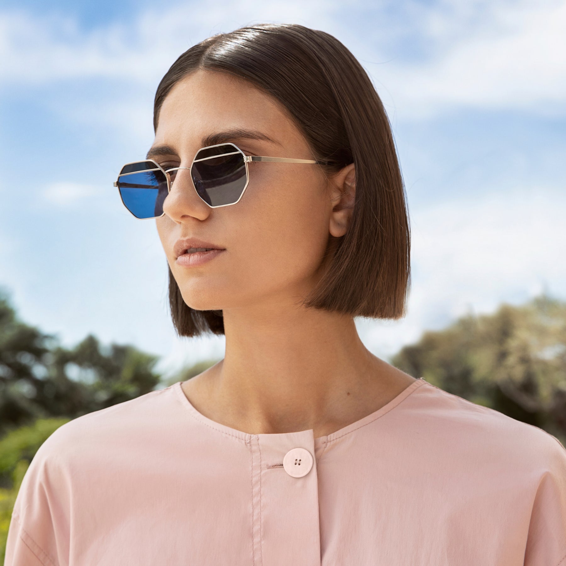 a woman wearing sunglasses and a white shirt 