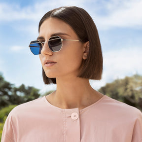 a woman wearing sunglasses and a white shirt 