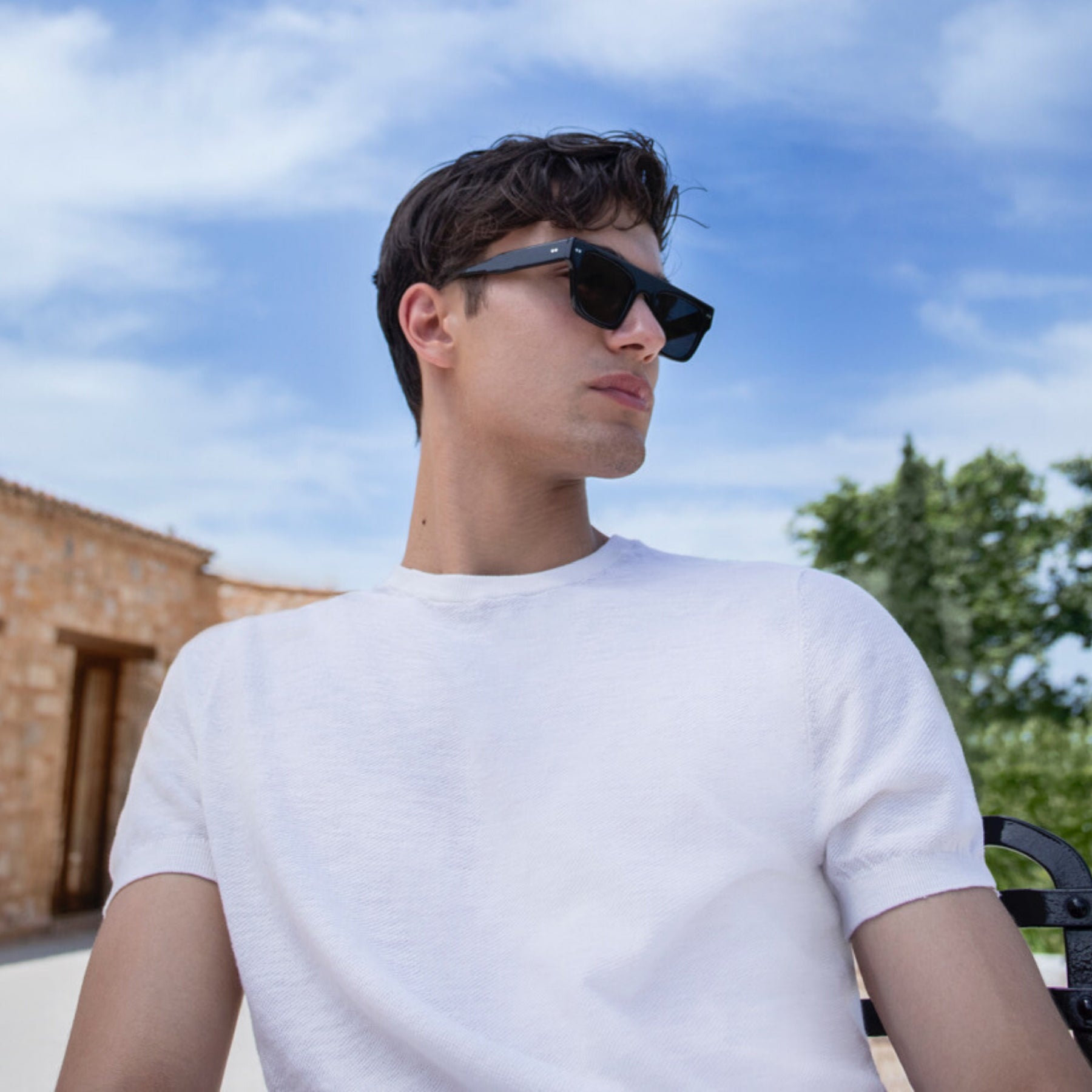 a man wearing sunglasses and a white shirt 