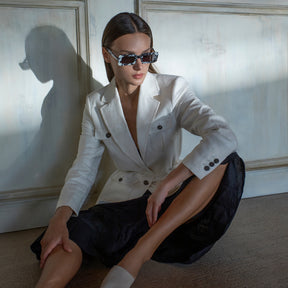 a woman sitting on a bench with sunglasses 