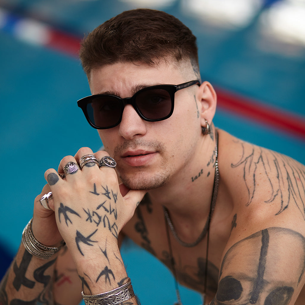 a man in sunglasses is sitting on a bench 