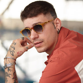 a man in sunglasses is talking on a cell phone 